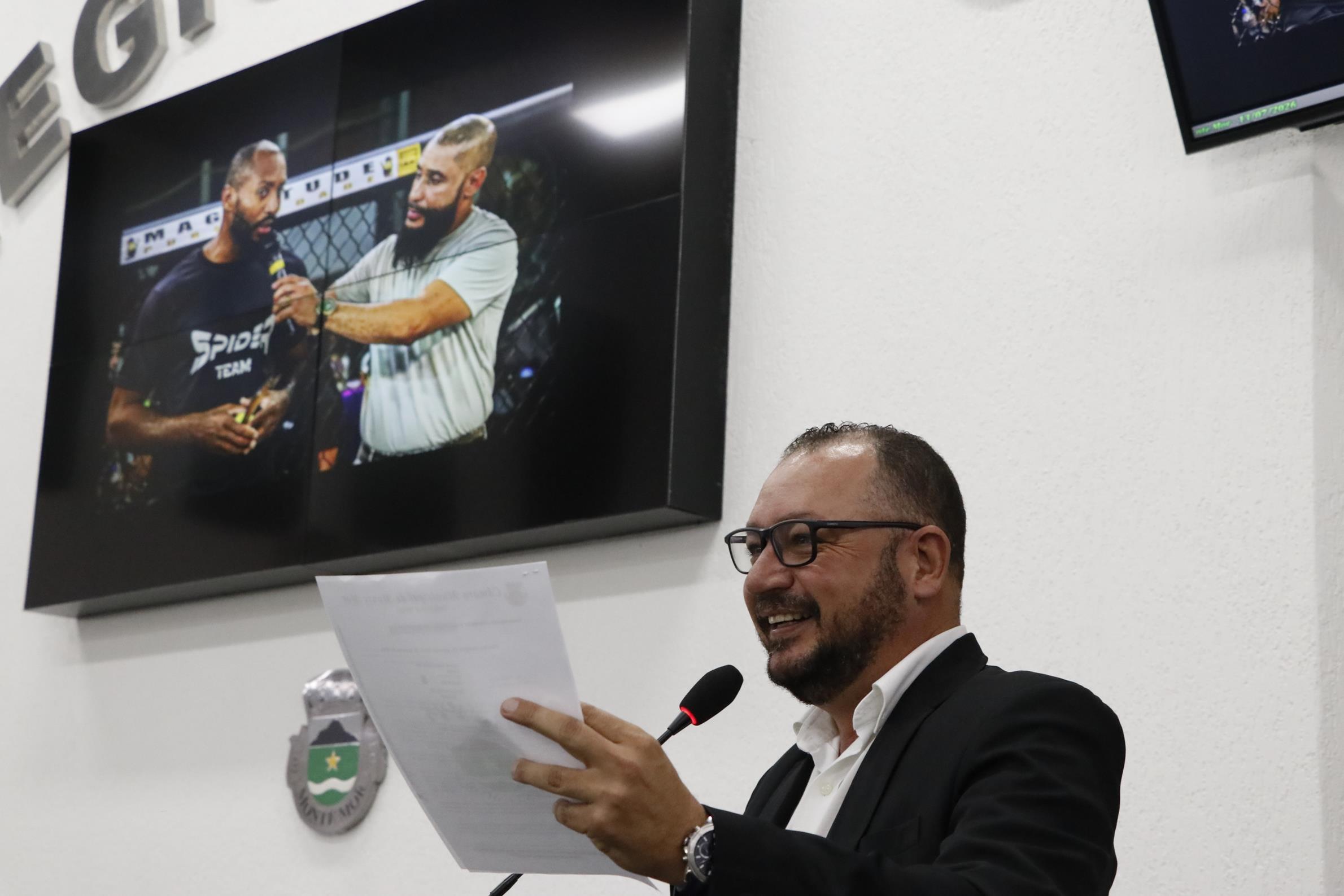 Beto Carvalho lendo a Moção de Aplausos; no telão, Spider ao microfone
